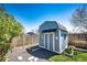 Well-maintained backyard featuring a storage shed, gravel area, and a green lawn at 862 Centennial Way, Bennett, CO 80102