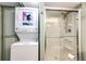 Efficient bathroom with a stacked washer-dryer and a modern glass-enclosed shower unit at 862 Centennial Way, Bennett, CO 80102