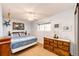 Well-lit bedroom featuring a large dresser and a view of the backyard from the window at 862 Centennial Way, Bennett, CO 80102