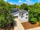 Aerial view of a well-manicured home with lush trees, a private driveway, and manicured landscaping at 202 Hoover Ave, Louisville, CO 80027