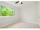 Bright bedroom features a large window, neutral walls, and a modern ceiling fan at 202 Hoover Ave, Louisville, CO 80027