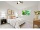 Serene bedroom featuring neutral tones, plush bedding, and natural light from the window at 202 Hoover Ave, Louisville, CO 80027
