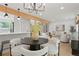 Open-concept design seamlessly connects the dining area, kitchen, and living room, with a stylish modern lighting fixture at 202 Hoover Ave, Louisville, CO 80027