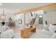 Open-concept living room with modern furnishings, wood accents, and view of staircase and kitchen at 202 Hoover Ave, Louisville, CO 80027