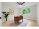 Bright home office with a modern desk, a patterned rug, and a large window overlooking lush greenery at 202 Hoover Ave, Louisville, CO 80027