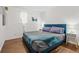 Bright bedroom with hardwood floors, a bed, pillows, lamps and a window at 5140 W 9Th Ave, Denver, CO 80204