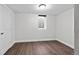 This bedroom features hardwood floors, a window and closet to the left and a fresh coat of white paint at 5140 W 9Th Ave, Denver, CO 80204