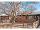 Beautiful brick home featuring a well-kept lawn, a sturdy fence, and a vibrant, mature tree at 5140 W 9Th Ave, Denver, CO 80204