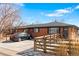 Brick home with a well-kept lawn and a sturdy fence, and car parking at the front at 5140 W 9Th Ave, Denver, CO 80204