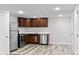 Bright basement kitchen with wood floors, stainless steel appliances, and white walls at 5140 W 9Th Ave, Denver, CO 80204