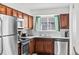 Modern kitchen featuring wooden cabinets, stainless steel appliances, and a bright window at 5140 W 9Th Ave, Denver, CO 80204