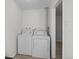 Neat laundry room featuring a white washer and dryer, with tile flooring and ample space at 5140 W 9Th Ave, Denver, CO 80204