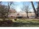 A charming backyard with a white fence, lush grass, and rustic decor at 7250 County Road 5, Erie, CO 80516