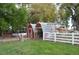 Exterior of a small outbuilding in a fenced, grassy yard with mature shade trees at 7250 County Road 5, Erie, CO 80516
