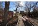 Rear yard of a property with a wooden bench and a patio surrounded by mature trees at 7250 County Road 5, Erie, CO 80516