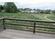 View from a wooden deck with railing overlooking an expansive grassy field and neighboring homes at 4812 S Bahama Way, Aurora, CO 80015