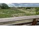 Back deck view of a grassy field, walking path, park, and other residential homes in the neighborhood at 4812 S Bahama Way, Aurora, CO 80015