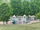 Community playground surrounded by mature trees and lush green space at 4812 S Bahama Way, Aurora, CO 80015