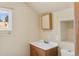 Bathroom with a wood vanity, sink, modern mirror and framed window bringing natural light to the space at 1104 Miner St, Idaho Springs, CO 80452