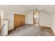 Bright bedroom features neutral walls, soft carpet, and a convenient closet with a view to the bathroom at 1104 Miner St, Idaho Springs, CO 80452
