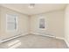 Bright bedroom with neutral carpet, baseboard heating, two windows, and a ceiling light at 1104 Miner St, Idaho Springs, CO 80452