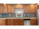 Attractive kitchen with wood cabinets, granite counters, stainless steel dishwasher, and lots of natural light at 1104 Miner St, Idaho Springs, CO 80452