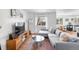 Cozy living room with hardwood floors, a gray sectional sofa, and a view into the dining area at 13124 Tejon St, Westminster, CO 80234