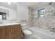 Updated bathroom features modern tile work, a sleek vanity, and contemporary fixtures with a shower and tub combo at 2601 W Amherst Ave, Denver, CO 80236