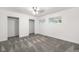 Bright bedroom featuring plush gray carpet, a closet, ceiling fan, and sunny double windows at 2601 W Amherst Ave, Denver, CO 80236