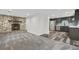 Inviting living area featuring a stunning stone fireplace, carpet, and an open flow to the updated kitchen at 2601 W Amherst Ave, Denver, CO 80236