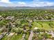 Vast aerial view of a town with lush greenery, scattered homes, and mountains in the background at 2445 Vance St, Lakewood, CO 80214