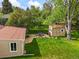Lush backyard with a patio, shed, and mature trees offering a private outdoor space at 2445 Vance St, Lakewood, CO 80214