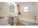 Cozy bathroom featuring a classic pedestal sink, tiled walls, and a tub with shower at 2445 Vance St, Lakewood, CO 80214