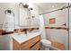 Modern bathroom with a wood vanity, neutral tiling, and a glass-enclosed walk-in shower at 2445 Vance St, Lakewood, CO 80214