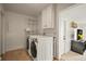 Laundry room with washer, dryer, storage cabinets, shelves, and tile floor at 2445 Vance St, Lakewood, CO 80214