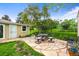 An inviting backyard patio has decorative table and seating amidst a well-manicured lawn at 2445 Vance St, Lakewood, CO 80214