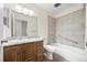 Bright bathroom with updated tile surround, wood vanity, and single sink at 7483 W Cedar Cir, Lakewood, CO 80226