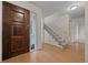 Inviting entryway with wood floors, stairwell, and paneled front door at 7483 W Cedar Cir, Lakewood, CO 80226