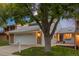 Charming home featuring attached two-car garage, brick accents, and a well-maintained front yard with mature tree at 7483 W Cedar Cir, Lakewood, CO 80226
