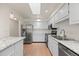 Bright kitchen featuring white cabinets, stainless steel appliances, granite countertops, and a skylight at 7483 W Cedar Cir, Lakewood, CO 80226