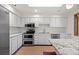 Bright kitchen featuring white cabinets, stainless steel appliances, and granite countertops at 7483 W Cedar Cir, Lakewood, CO 80226