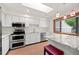 Bright kitchen with white cabinets, stainless steel appliances, granite counters and a skylight at 7483 W Cedar Cir, Lakewood, CO 80226