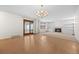 Spacious living room featuring hardwood floors, built-in bookshelves, fireplace and sliding glass door to deck at 7483 W Cedar Cir, Lakewood, CO 80226