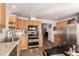 Bright kitchen features stainless steel appliances, wood cabinets, and granite counters at 6105 Needlegrass # 307, Frederick, CO 80530