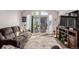 Inviting living room features sunlight, brown couches, and a sliding glass door at 6105 Needlegrass # 307, Frederick, CO 80530