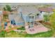 Aerial view of the blue two-story home with a backyard featuring a patio and pergola for outdoor entertaining at 15767 E 109Th Ave, Commerce City, CO 80022