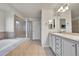 Bathroom with double sinks, tiled floors and walls, a separate shower, and a soaking tub at 15767 E 109Th Ave, Commerce City, CO 80022