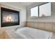 Bathroom with a soaking tub and fireplace at 15767 E 109Th Ave, Commerce City, CO 80022