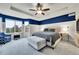 Beautiful bedroom featuring a tray ceiling, ceiling fan, and charming blue accent wall, with a large upholstered bed at 15767 E 109Th Ave, Commerce City, CO 80022