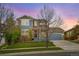 Charming two-story home featuring a blend of blue siding and stone accents with a well-manicured lawn at 15767 E 109Th Ave, Commerce City, CO 80022